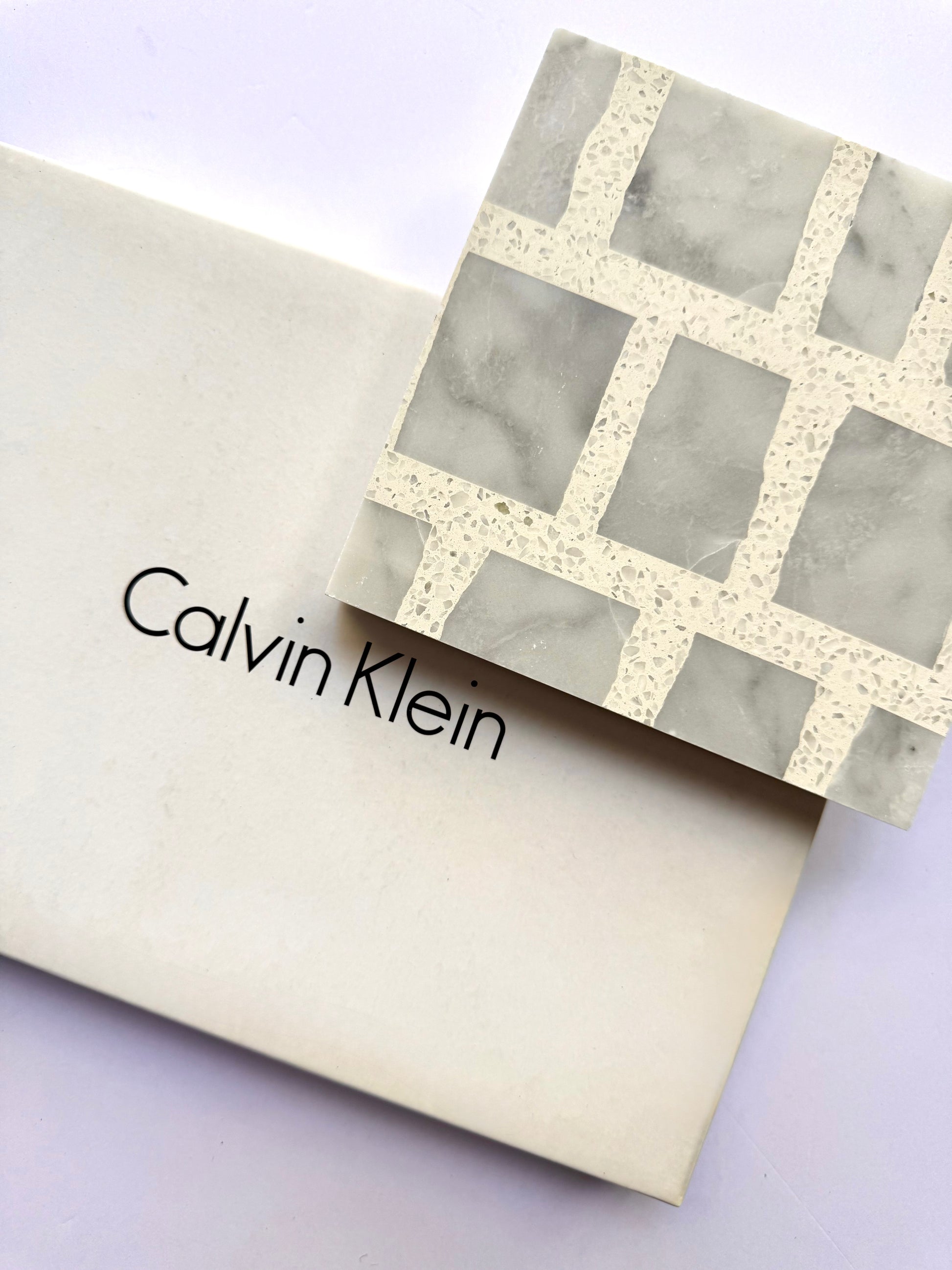 A New York Cement Tile box with a Carlo Scarpa - Grey Dusk geometric-patterned tile placed on top.