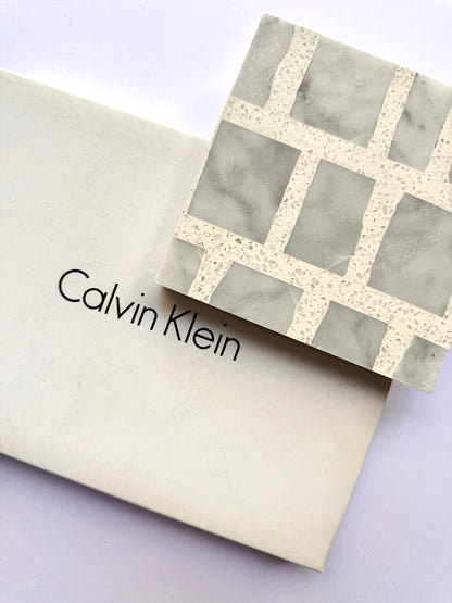 A New York Cement Tile box with a Carlo Scarpa - Grey Dusk geometric-patterned tile placed on top.