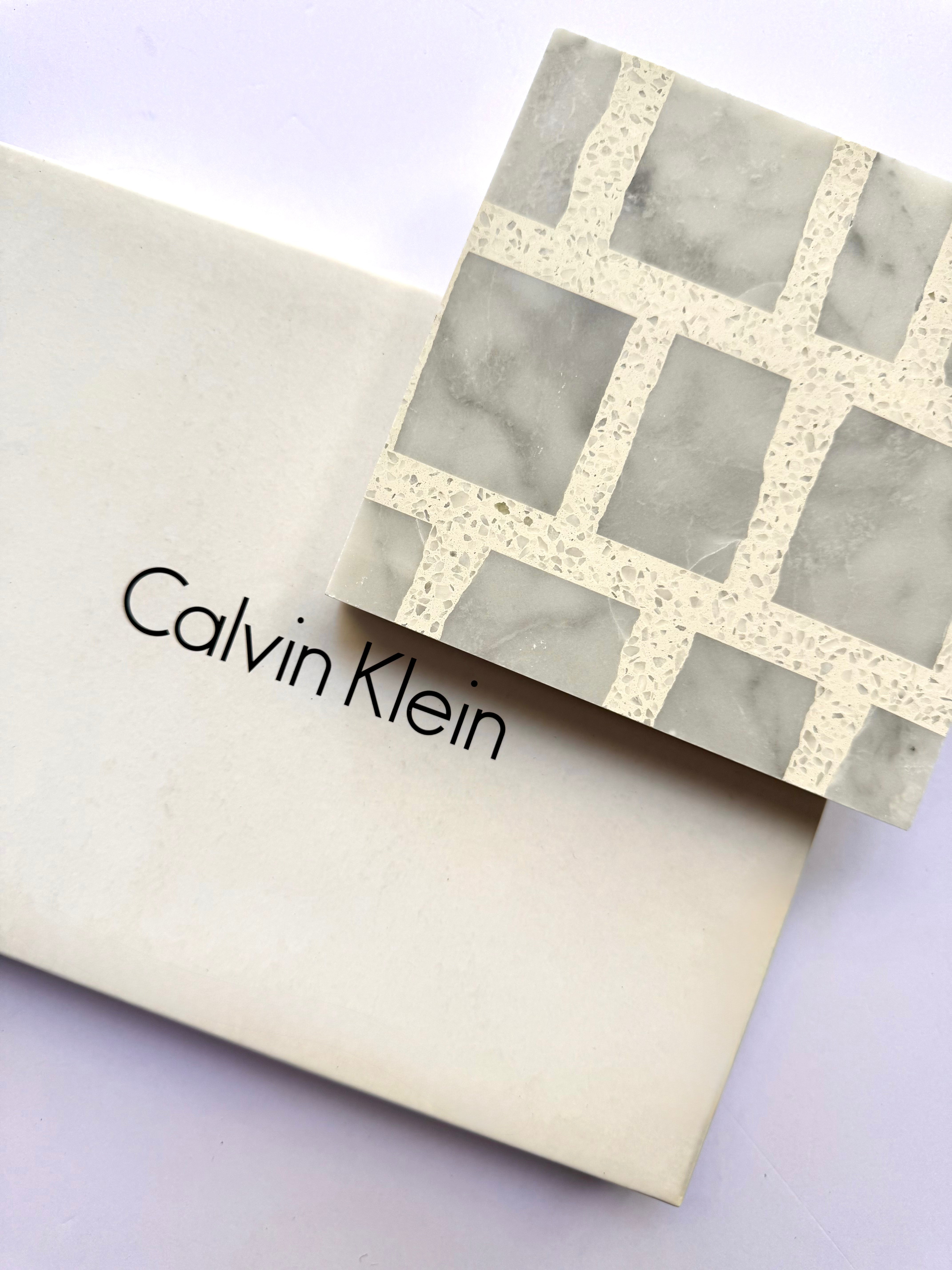 A New York Cement Tile box with a Carlo Scarpa - Grey Dusk geometric-patterned tile placed on top.