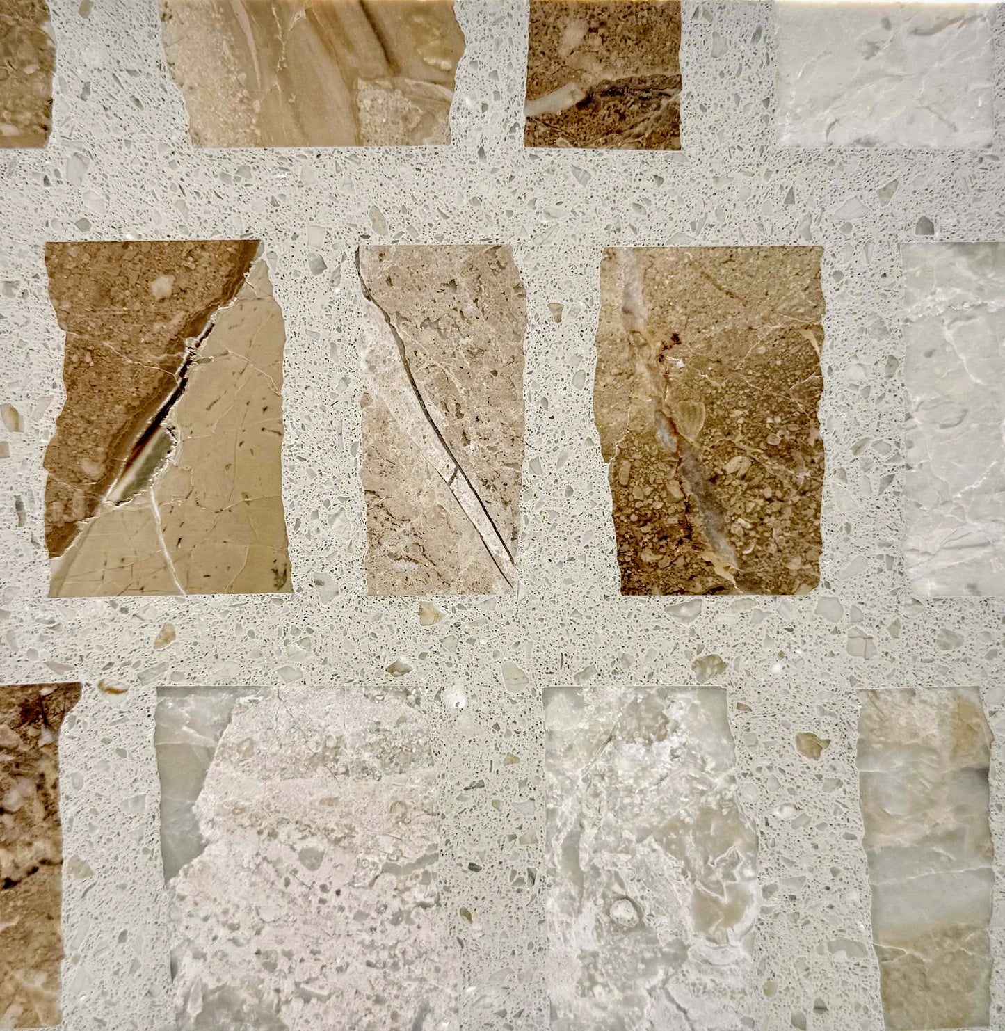 Close-up of Carlo Scarpa - Desert mosaic tile by New York Cement Tile in beige, brown, and cream with light grout.