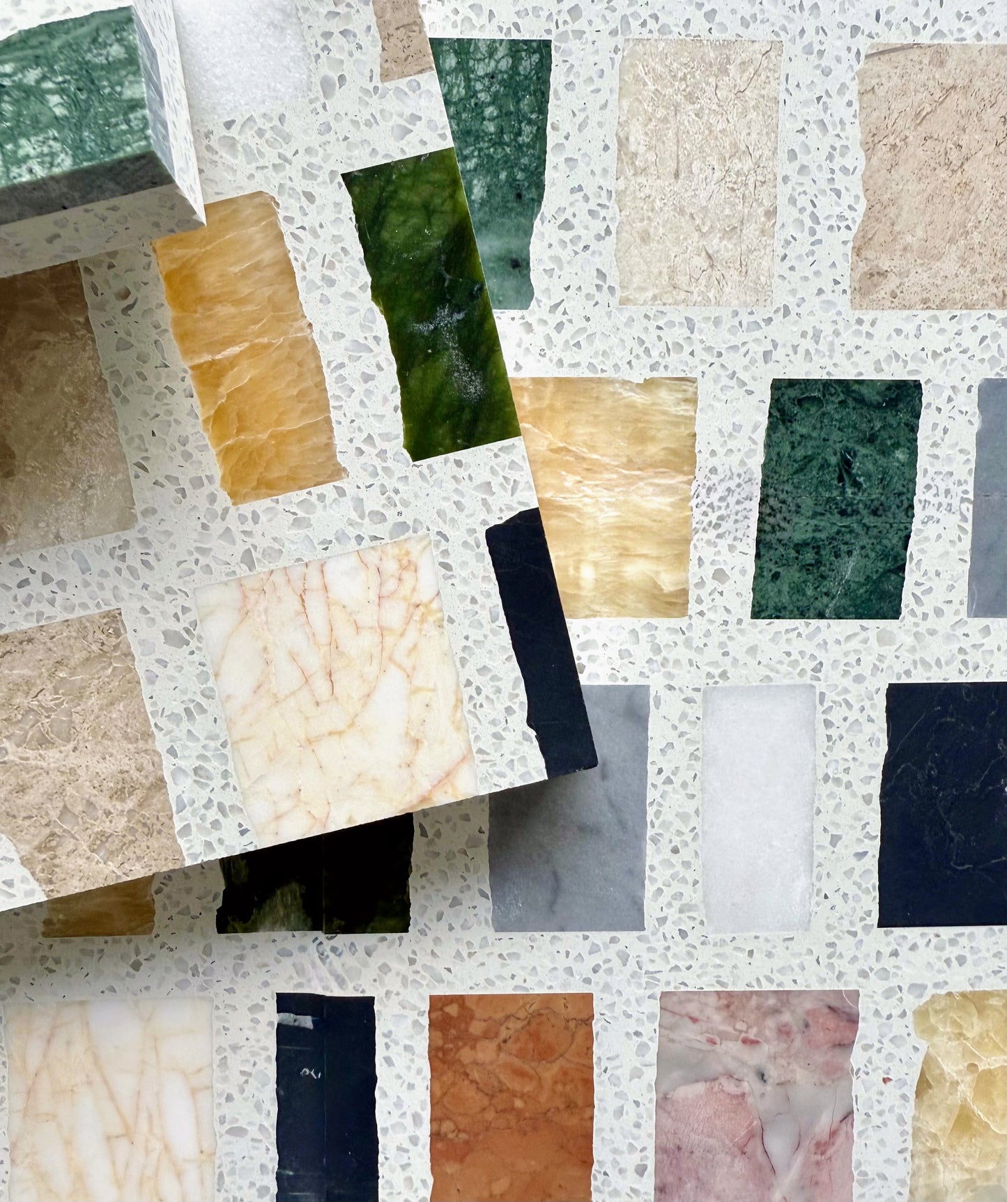 Carlo Scarpa-Multicolor tiles from New York Cement Tile are arranged in a grid on a terrazzo-style background.
