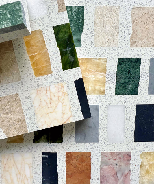 Carlo Scarpa-Multicolor tiles from New York Cement Tile are arranged in a grid on a terrazzo-style background.