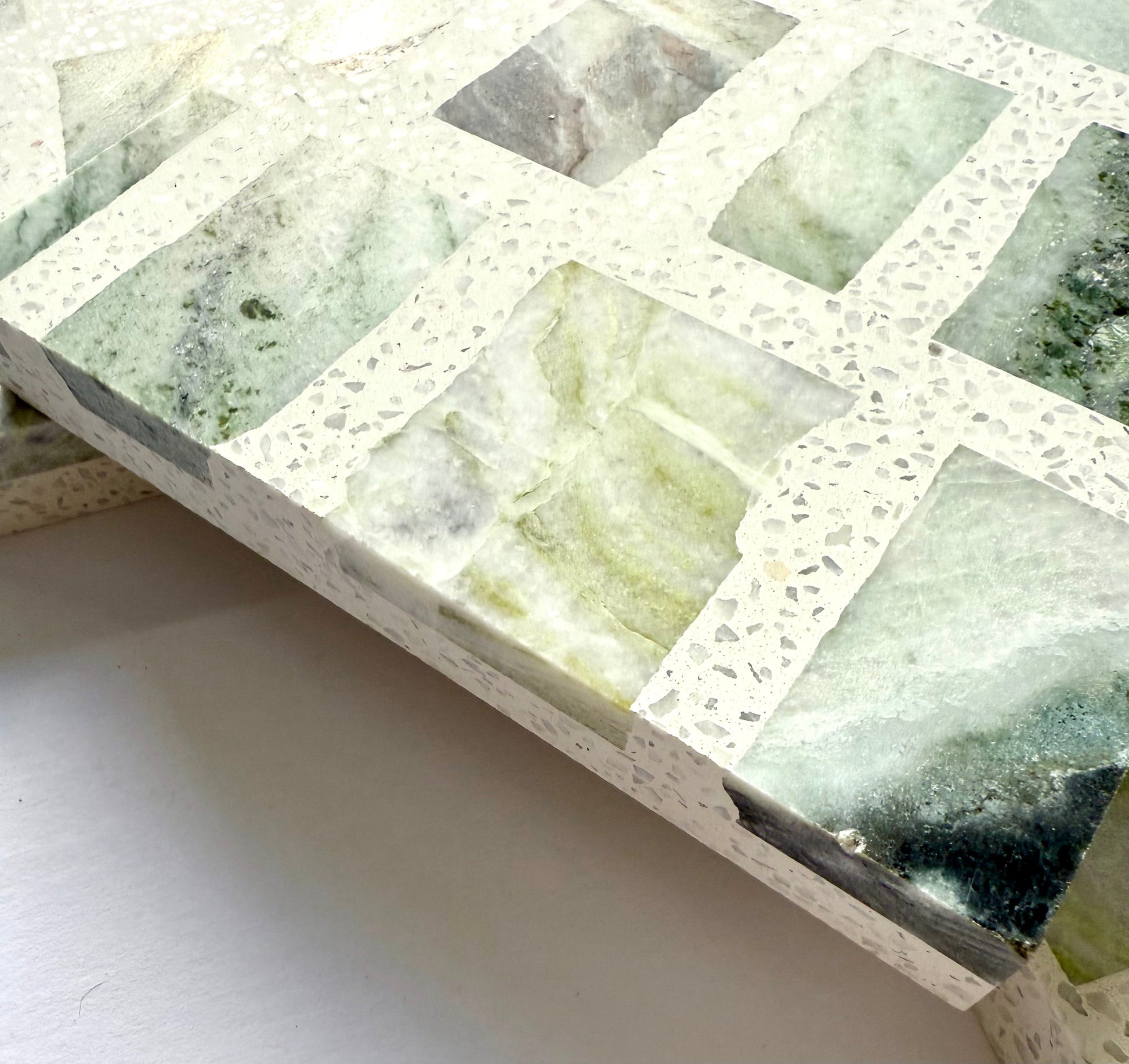 Close-up of Carlo Scarpa - Green Vibes terrazzo by New York Cement Tile, featuring green and white stone inlays.