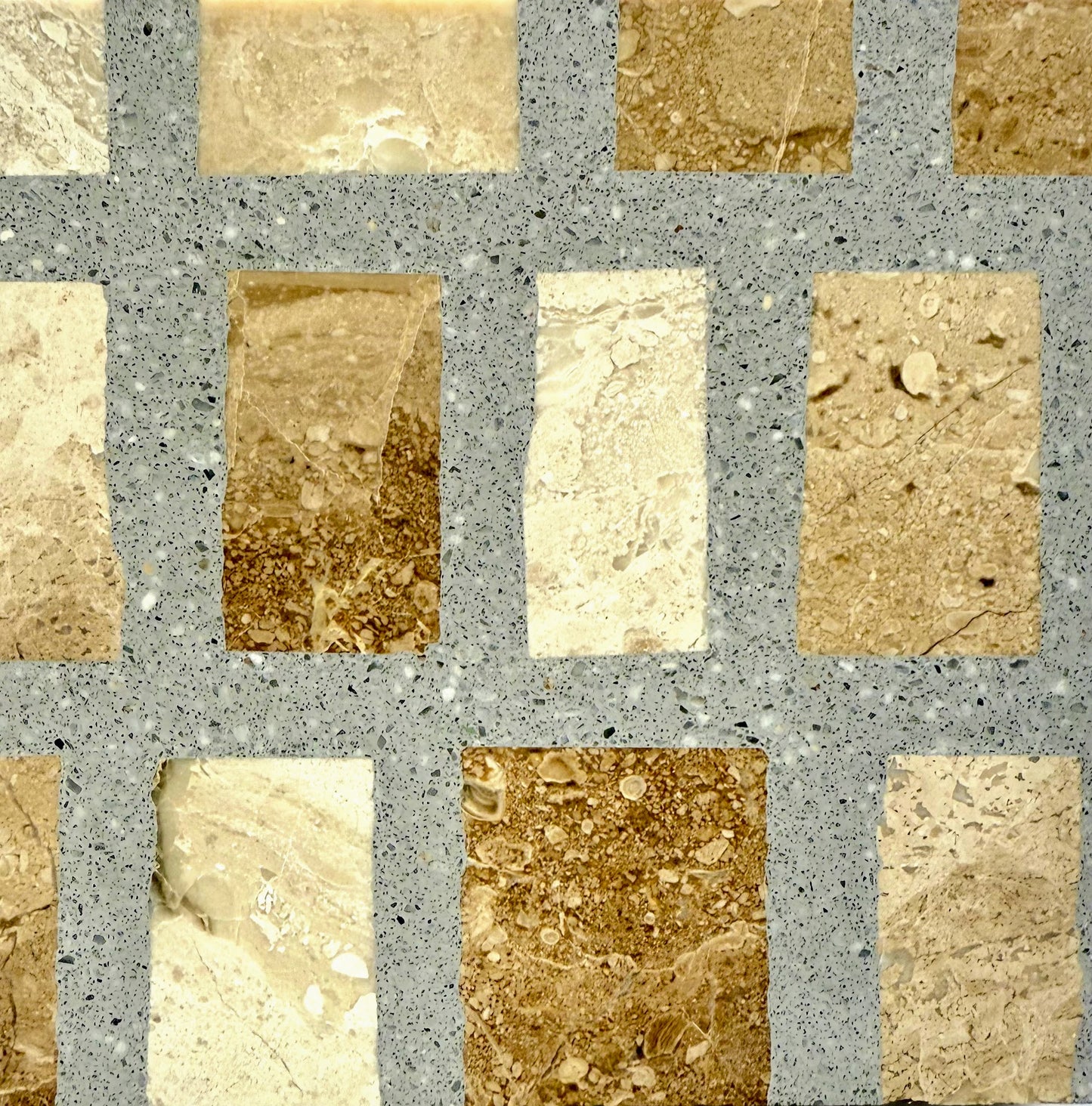 A grid of Carlo Scarpa - Cappuccino Gray tiles by New York Cement Tile set in a speckled gray surface.