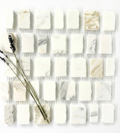 Scarpa I Calacatta Gold Marble Mesh by New York Cement Tile, white/beige marble tile with dried lavender sprigs on top.