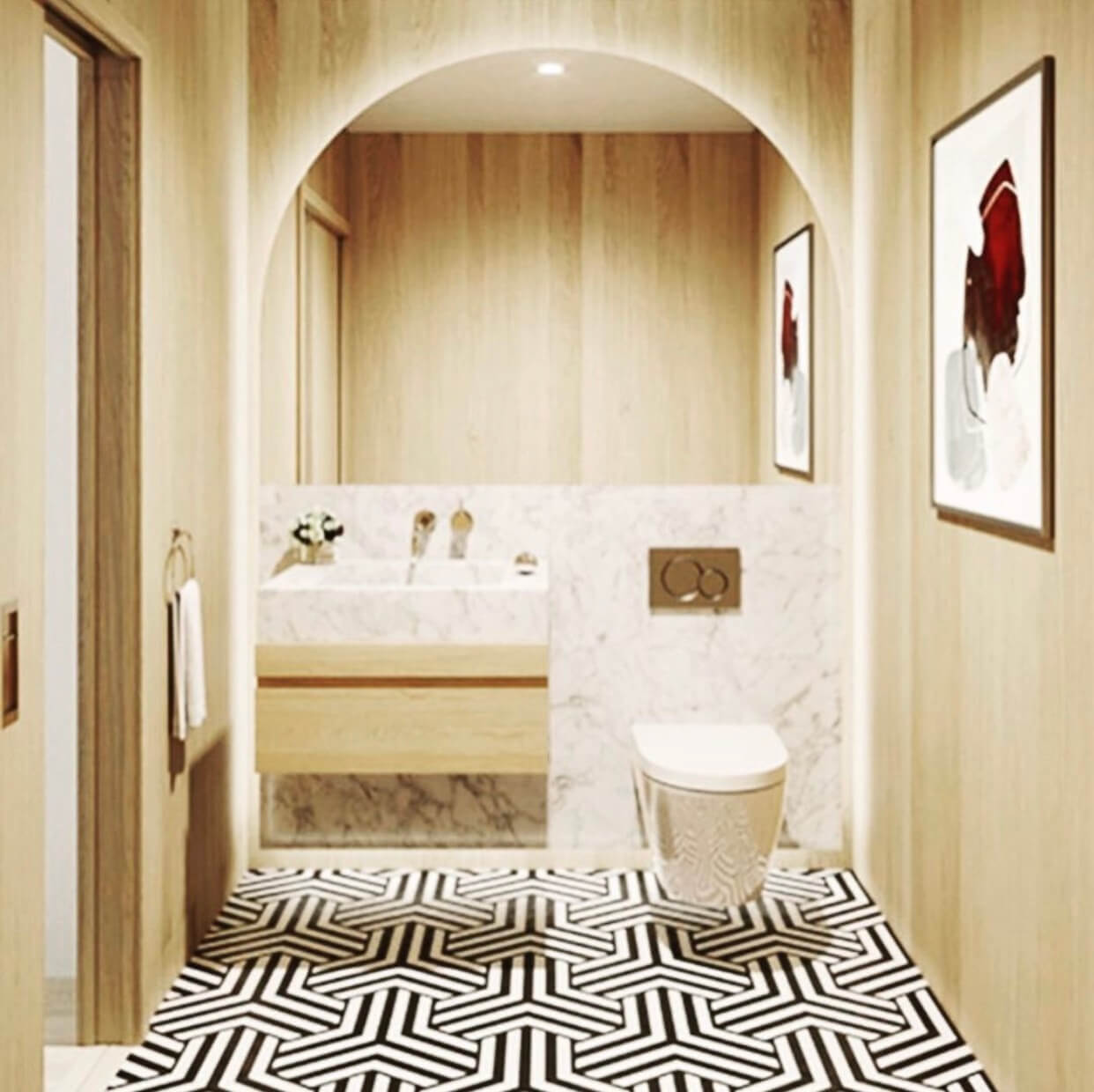 Modern bathroom with wood walls, marble sink and toilet, geometric black-and-white floor, and abstract art on the walls.