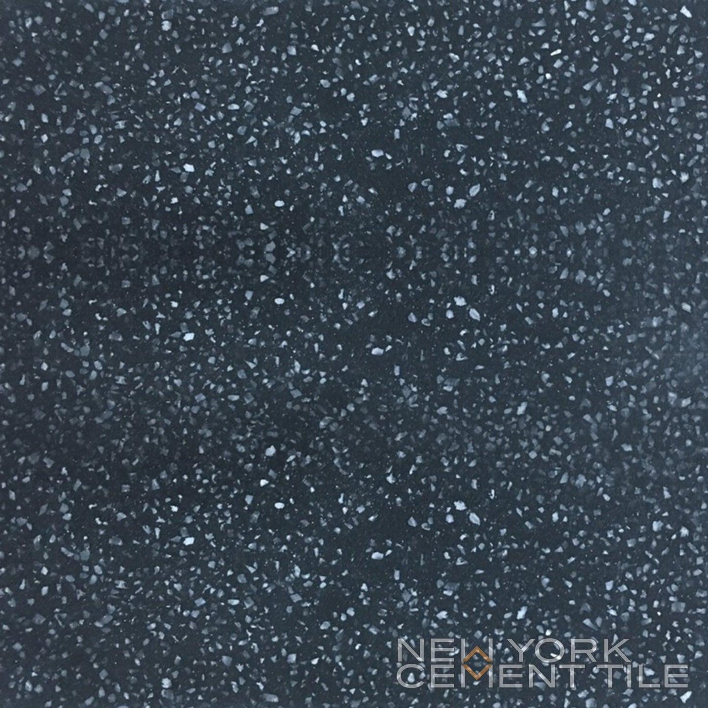 Terrazzo 8X8 - Solid Black tile sample by New York Cement Tile features small light gray and white chips in a mosaic look.