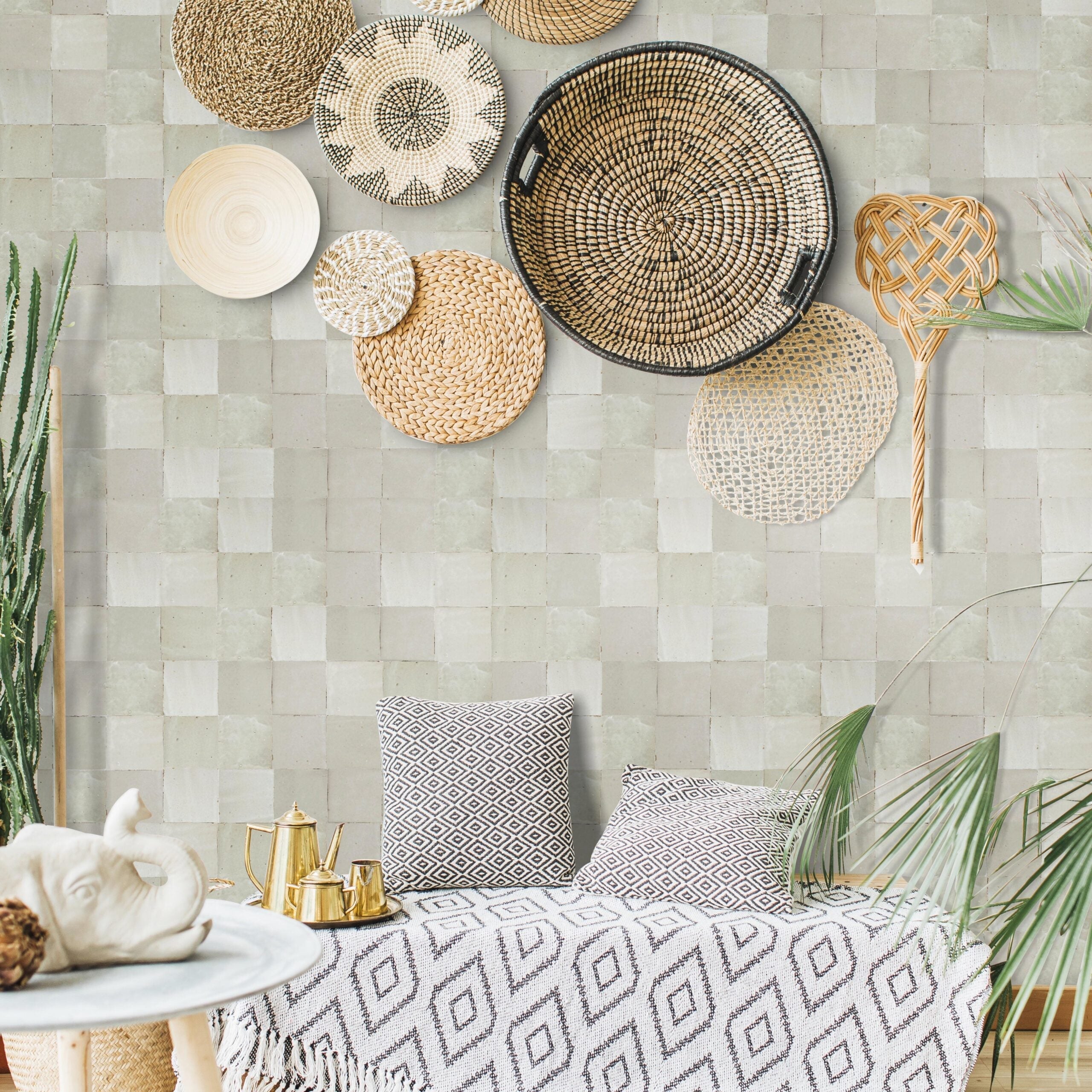 A cozy room features Pearl Grey 2X2 tiles by New York Cement Tile, with baskets, pillows, plants, and a gold tea set.