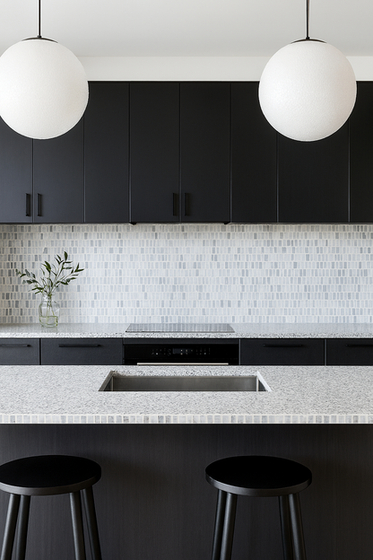 Modern kitchen with black cabinets, Carlo Scarpa - Grey Dusk tiles by New York Cement Tile, globe pendants, and marble island.