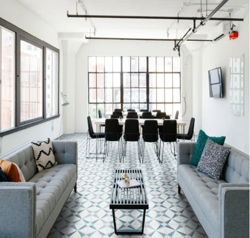 Modern office lounge with gray sofas and Polaris Azul cement tiles by New York Cement Tile, plus a conference table.