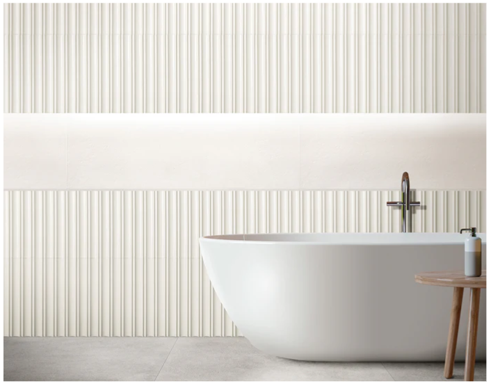 Modern bathroom with a TUBAGE-WHITE tub by New York Cement Tile, ribbed wall tiles, and sculptural details throughout.