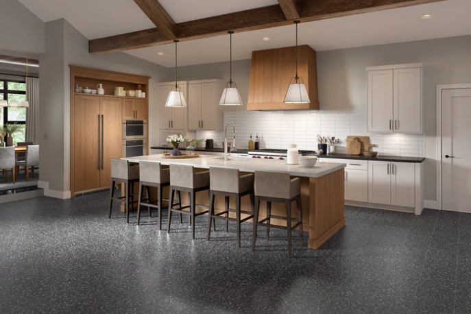 Modern kitchen with large island, pendant lights, white cabinets, and terrazzo floors by New York Cement Tile.