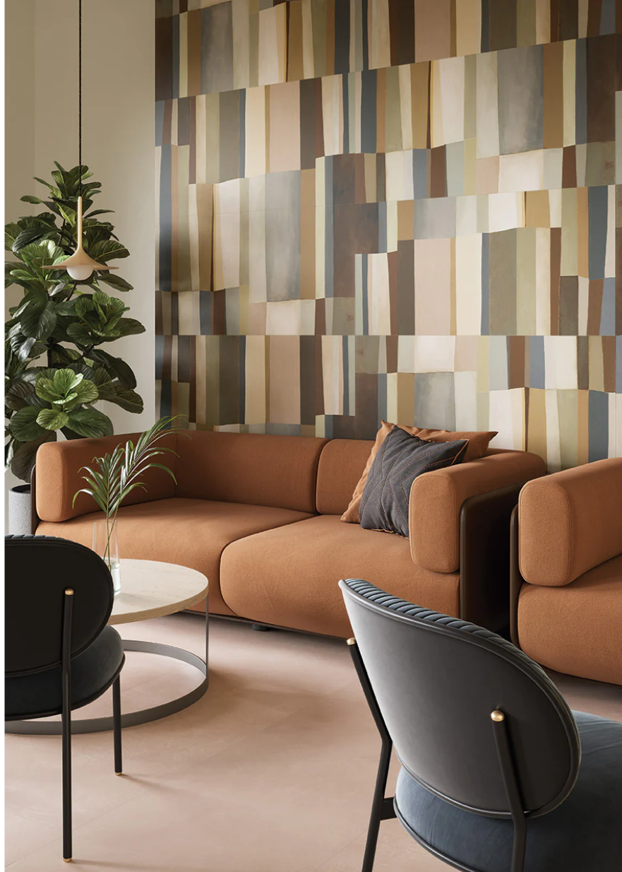 Modern living room with brown sofas, blue chairs, AGIO-24X47 SLIM-Equ tile by New York Cement Tile, and a tall green plant.