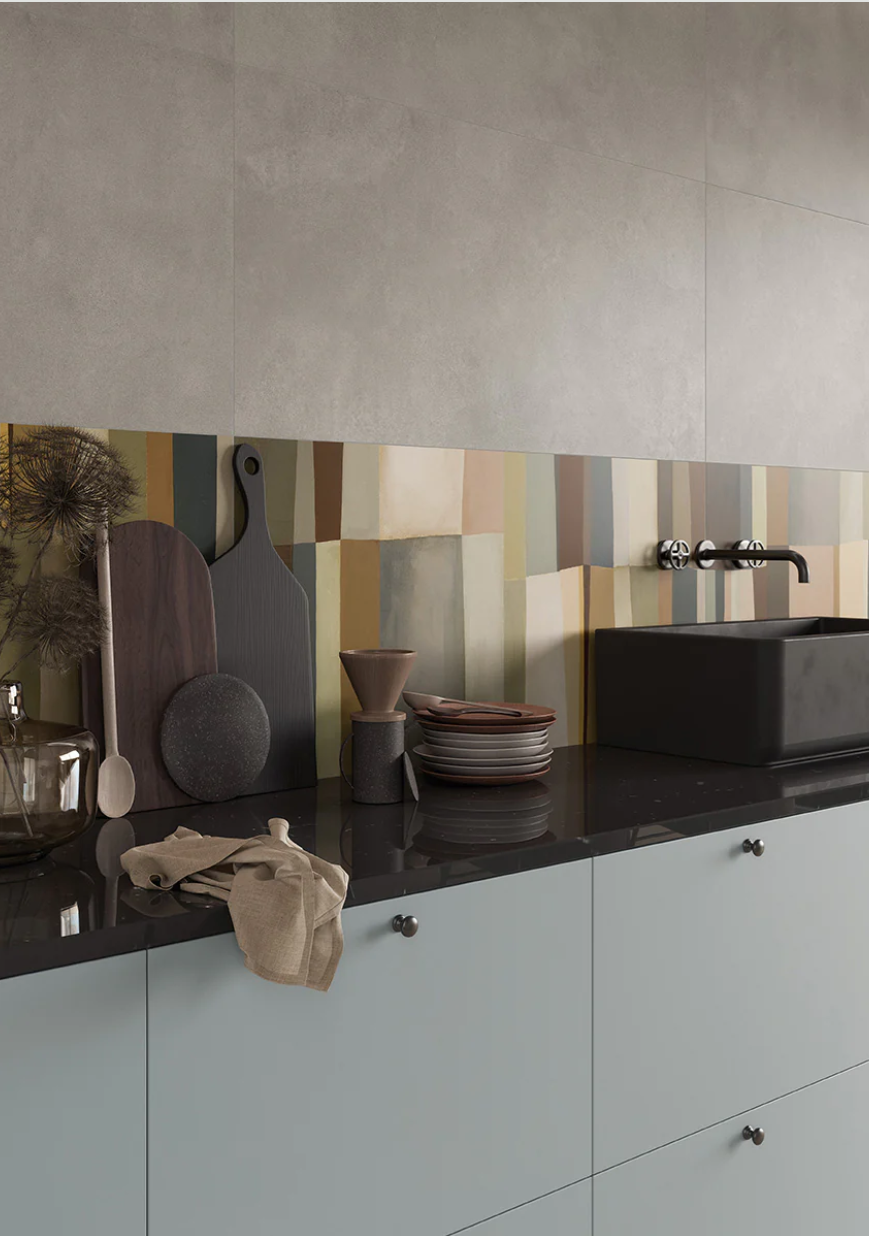 Modern kitchen with pastel cabinets, black countertop, and AGIO 24x47 Slim tiles by New York Cement Tile for a fresh look.