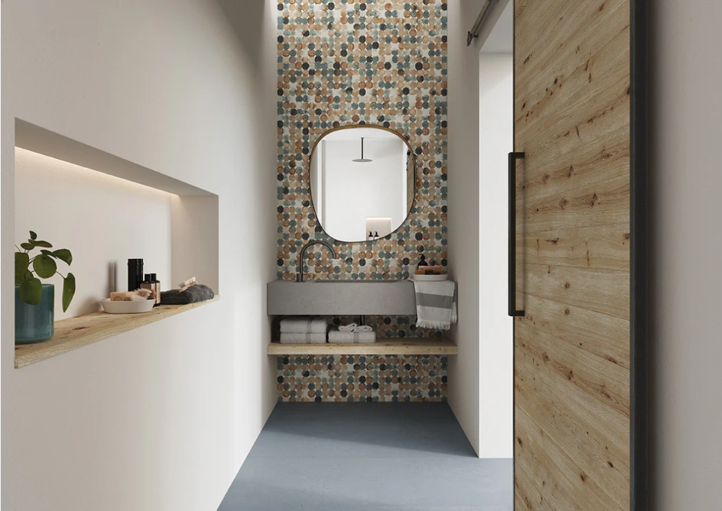 Modern bathroom with AGIO 24" x 47" SLIM-Ovale tile by New York Cement Tile, round mirror, and wooden sliding door.