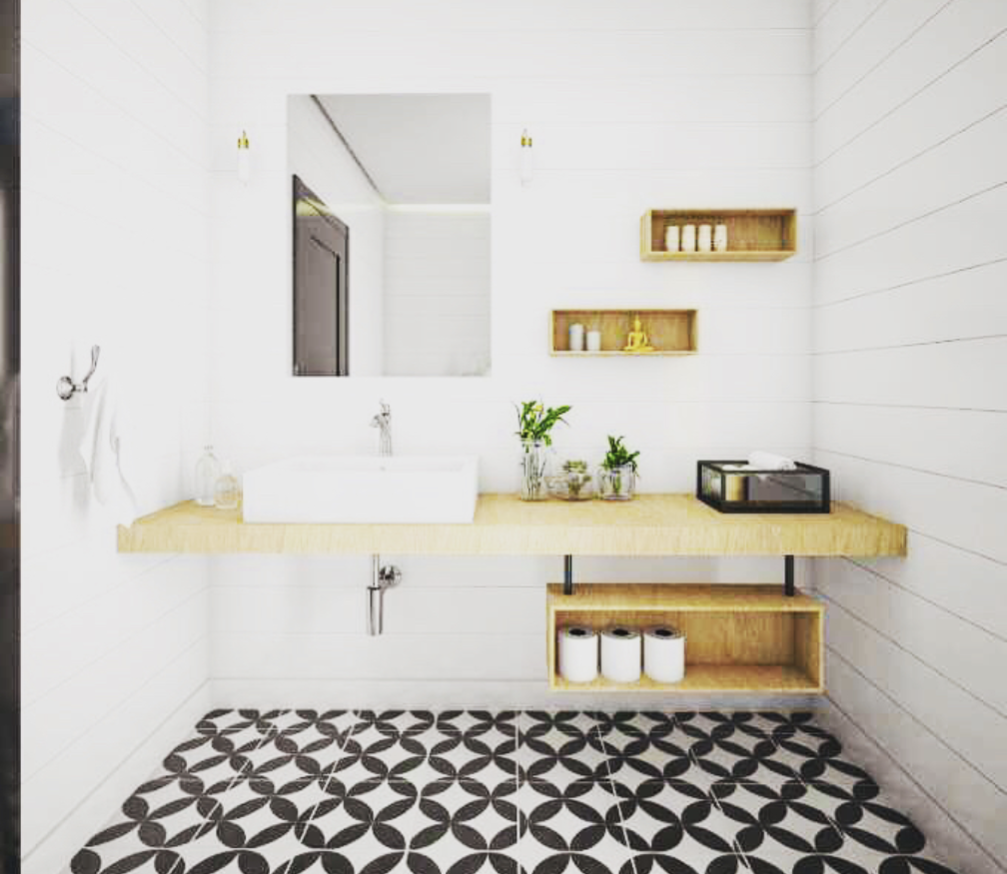 Modern bathroom with a floating wood vanity, plants, shelves, and geometric black-and-white patterned floor tiles.