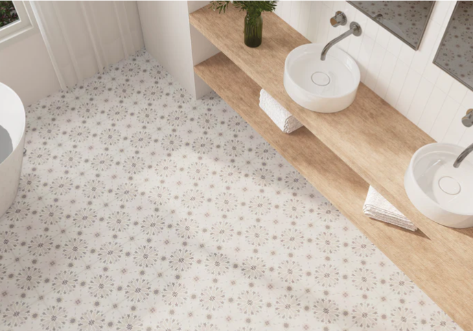 Bathroom with patterned tile floor, double sinks on a wooden countertop, mirrors, and neatly folded towels.