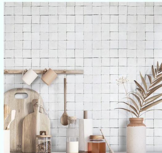 Frost 2X2 tiles by New York Cement Tile are shown behind wooden utensils, bottles, and a ceramic vase with dried leaves.