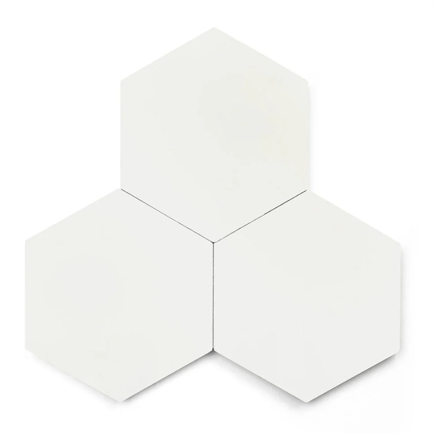 Three Solid Hex- White tiles by New York Cement Tile, clustered together on a plain background.
