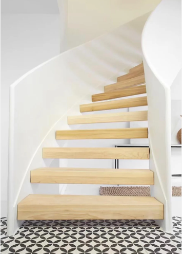 Modern spiral staircase with light wood steps, white curved railing, and geometric black-and-white patterned floor tiles.