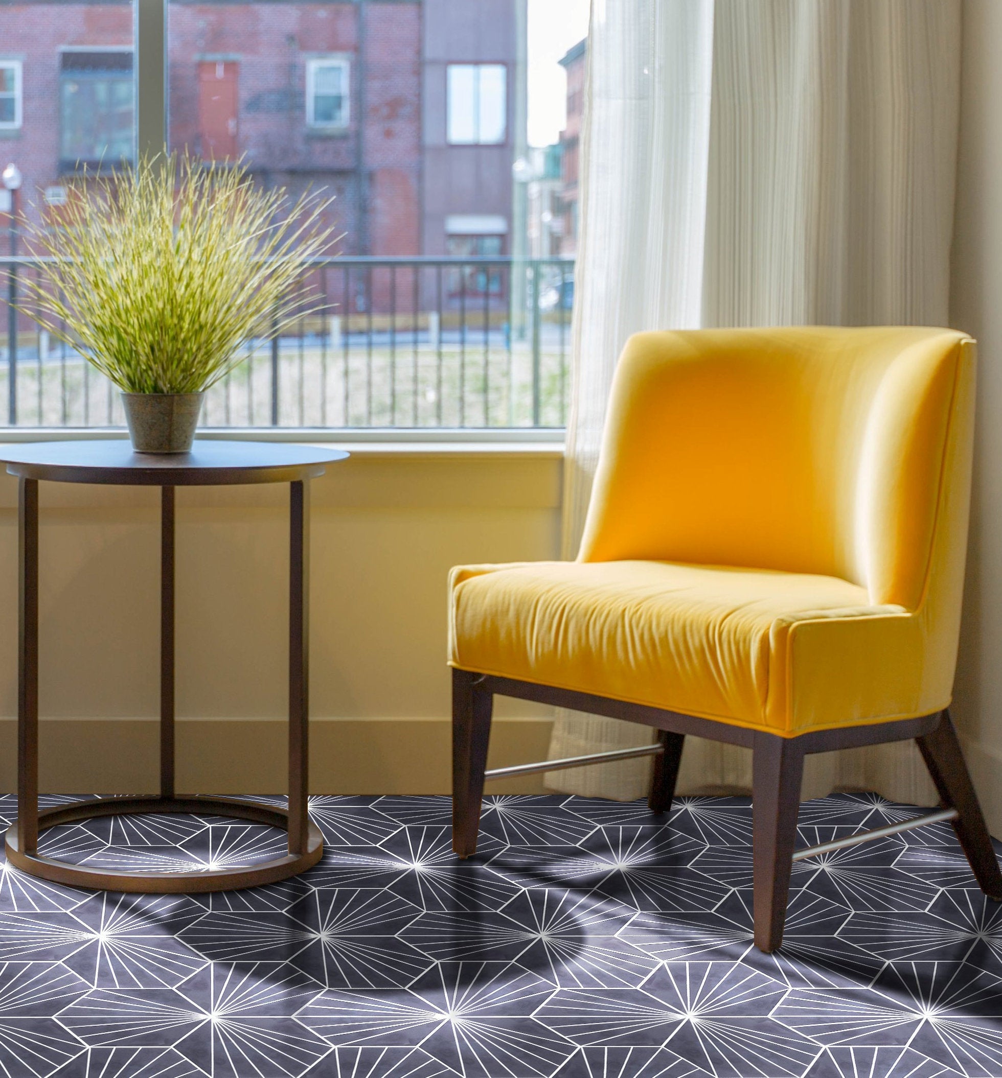 NH23-036 Black cement tile by New York Cement Tile on the floor, near a yellow chair and round table with a potted plant.