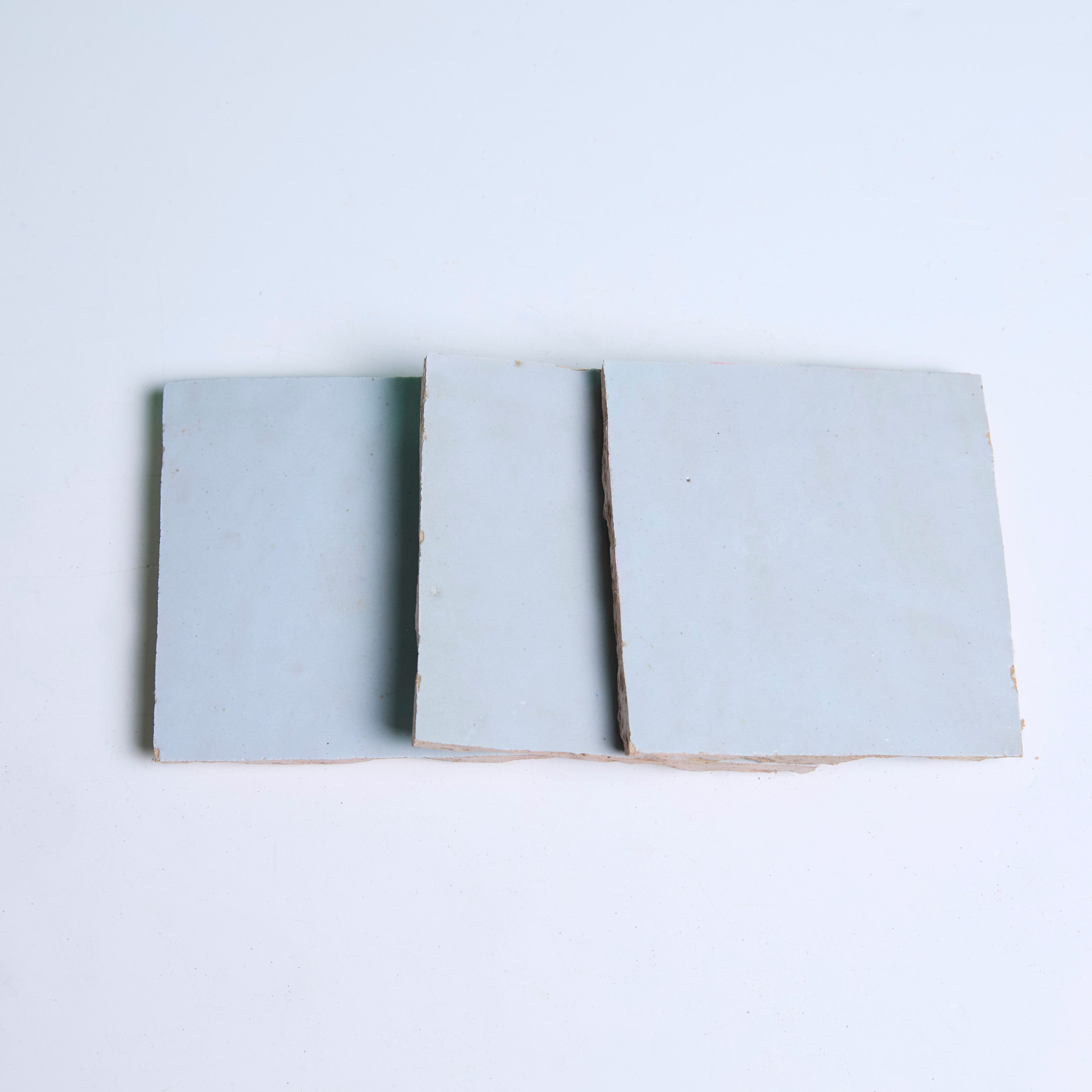 Three Magical Blue tiles by New York Cement Tile are arranged side by side on a white surface.