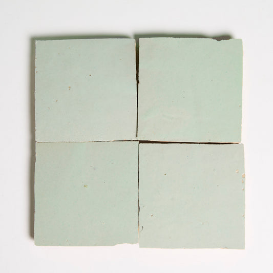 Four Mint Frost Zellige tiles by New York Cement Tile in a grid, pale green with slight gaps on a white background.