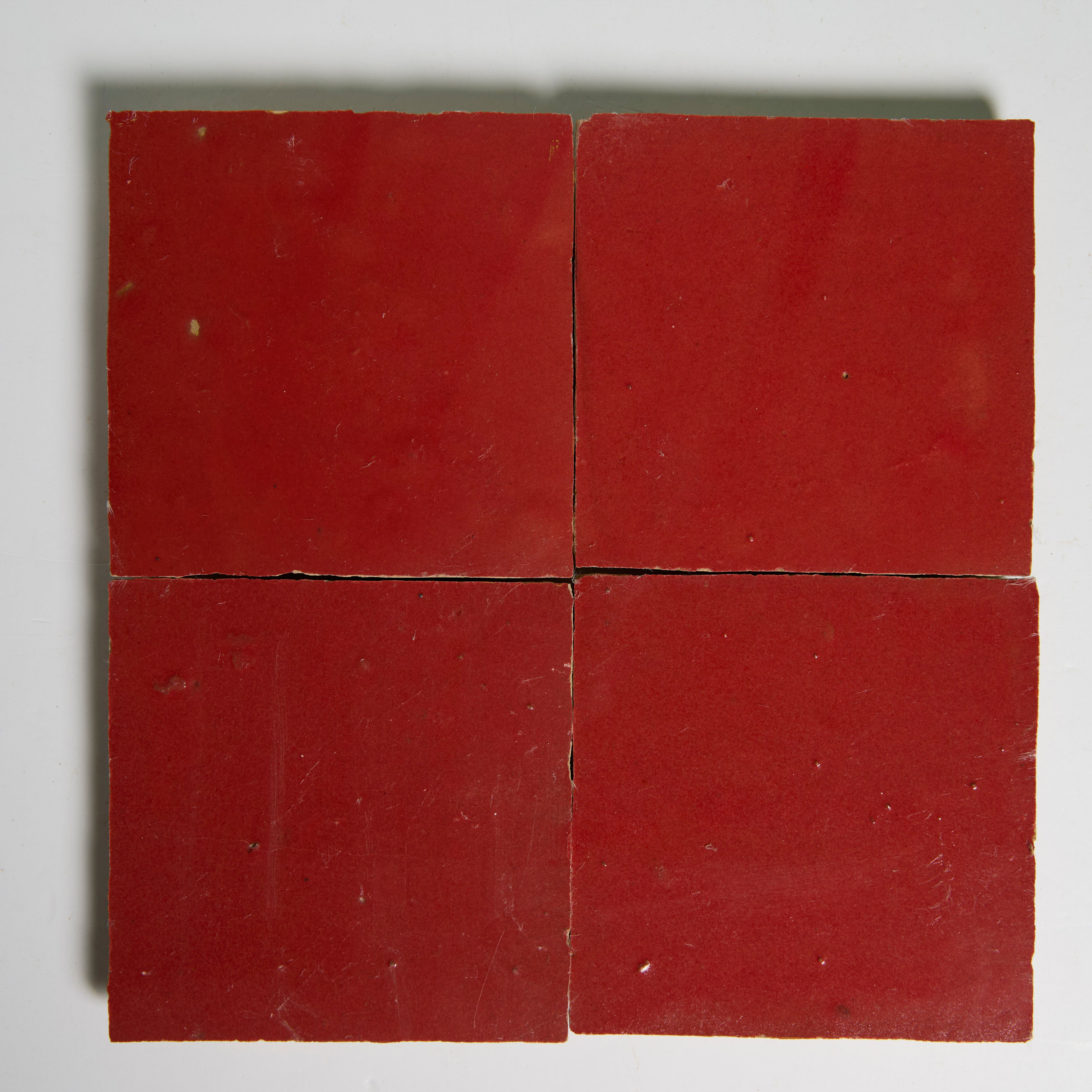 Four Fiery Red tiles by New York Cement Tile arranged in a grid on white, with slight gaps between each one.