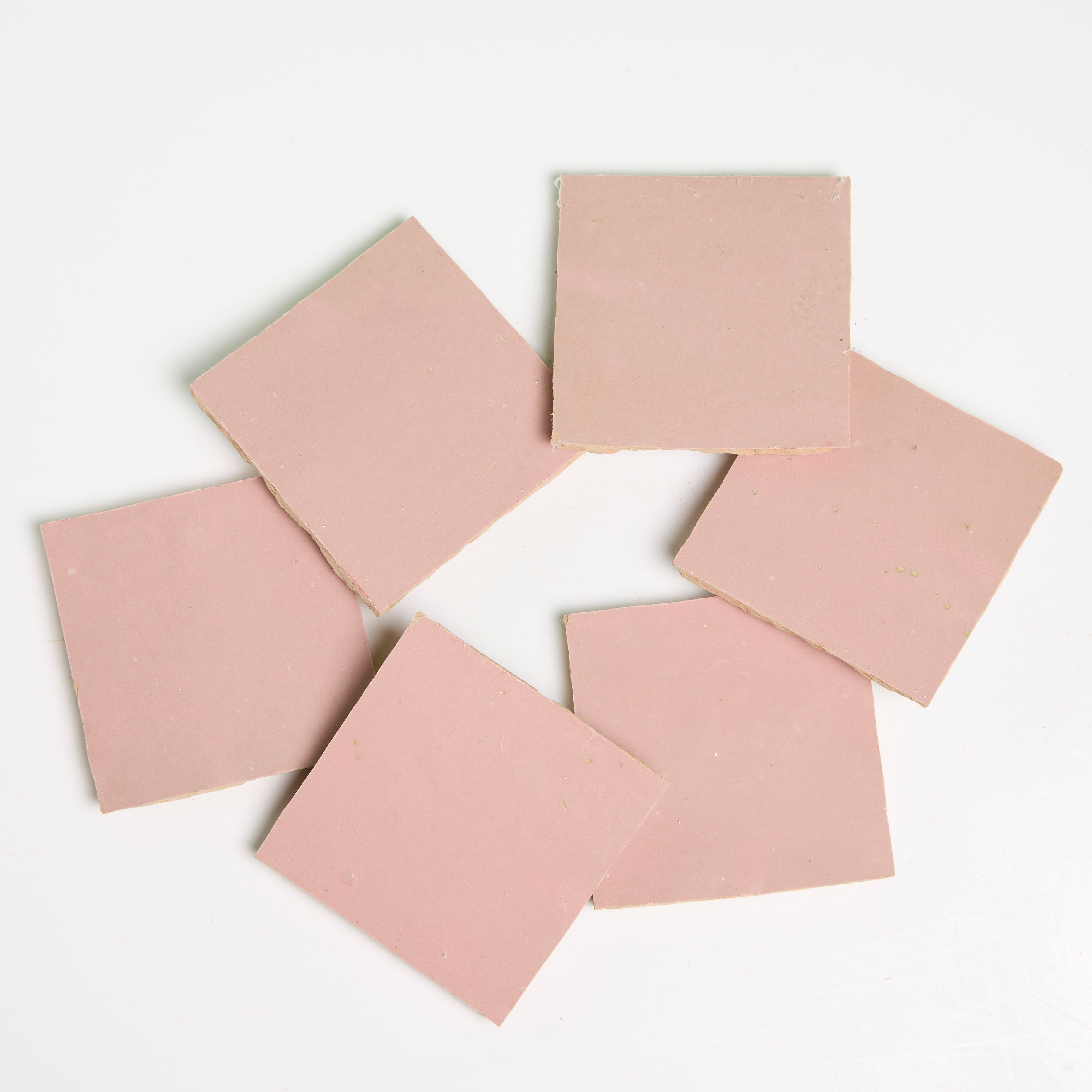 Six slices of Rosy Pink by New York Cement Tile are arranged like handcrafted tiles on a white background.