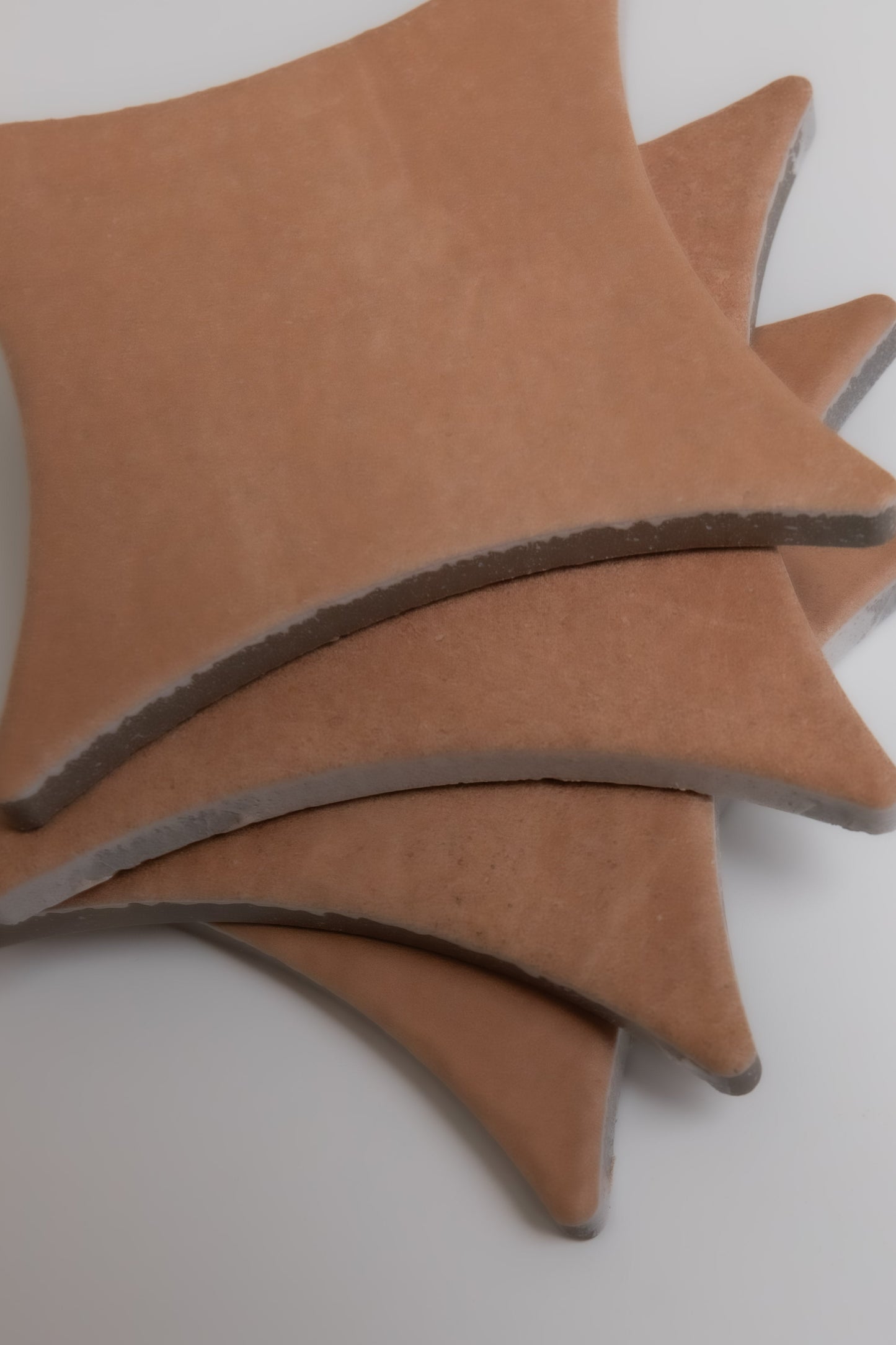 Three overlapping, star-shaped Arcilla tiles by Finca with pointed edges are displayed on a white background.