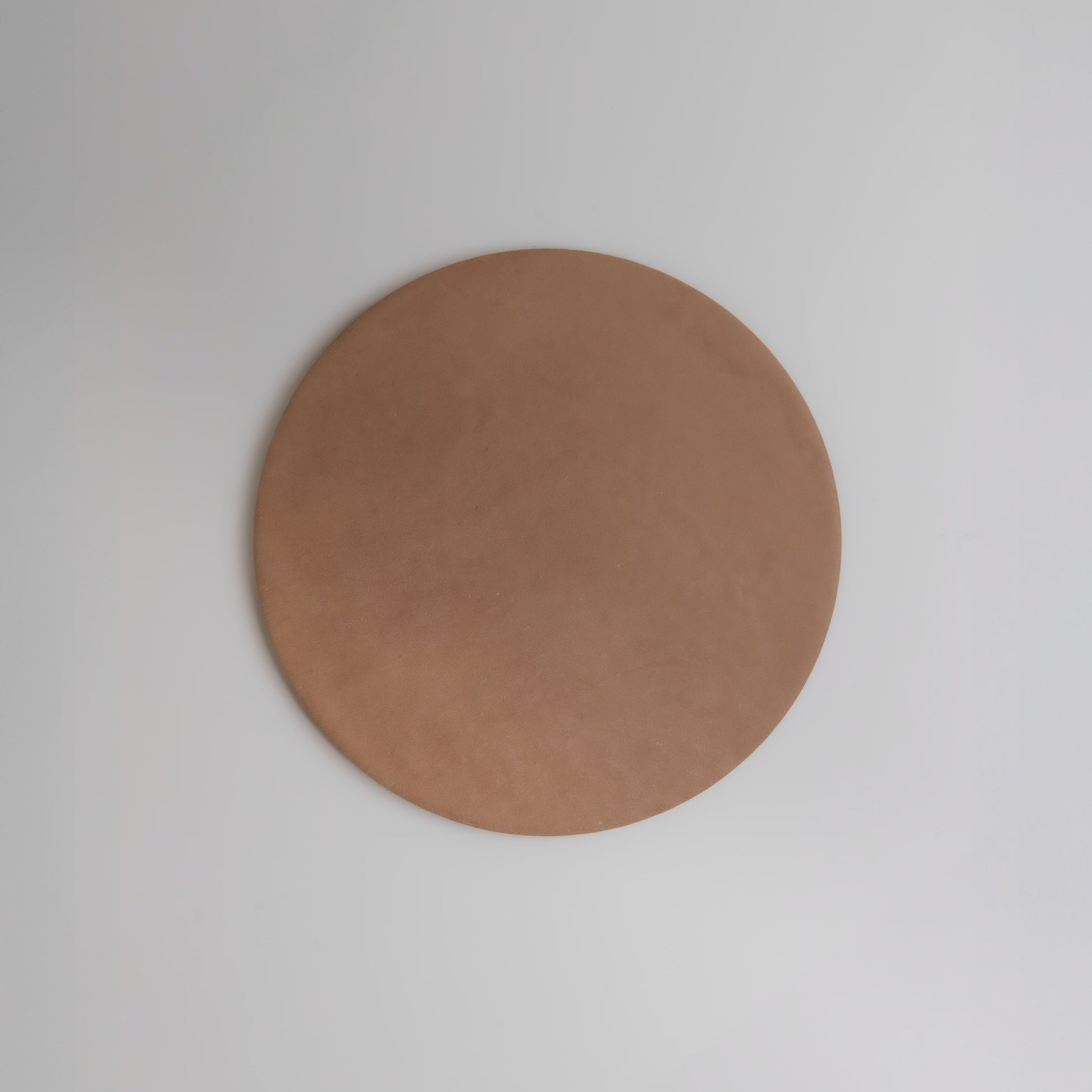 The Finca Arcilla Sample is a round, flat, brown disc displayed on a plain white background.