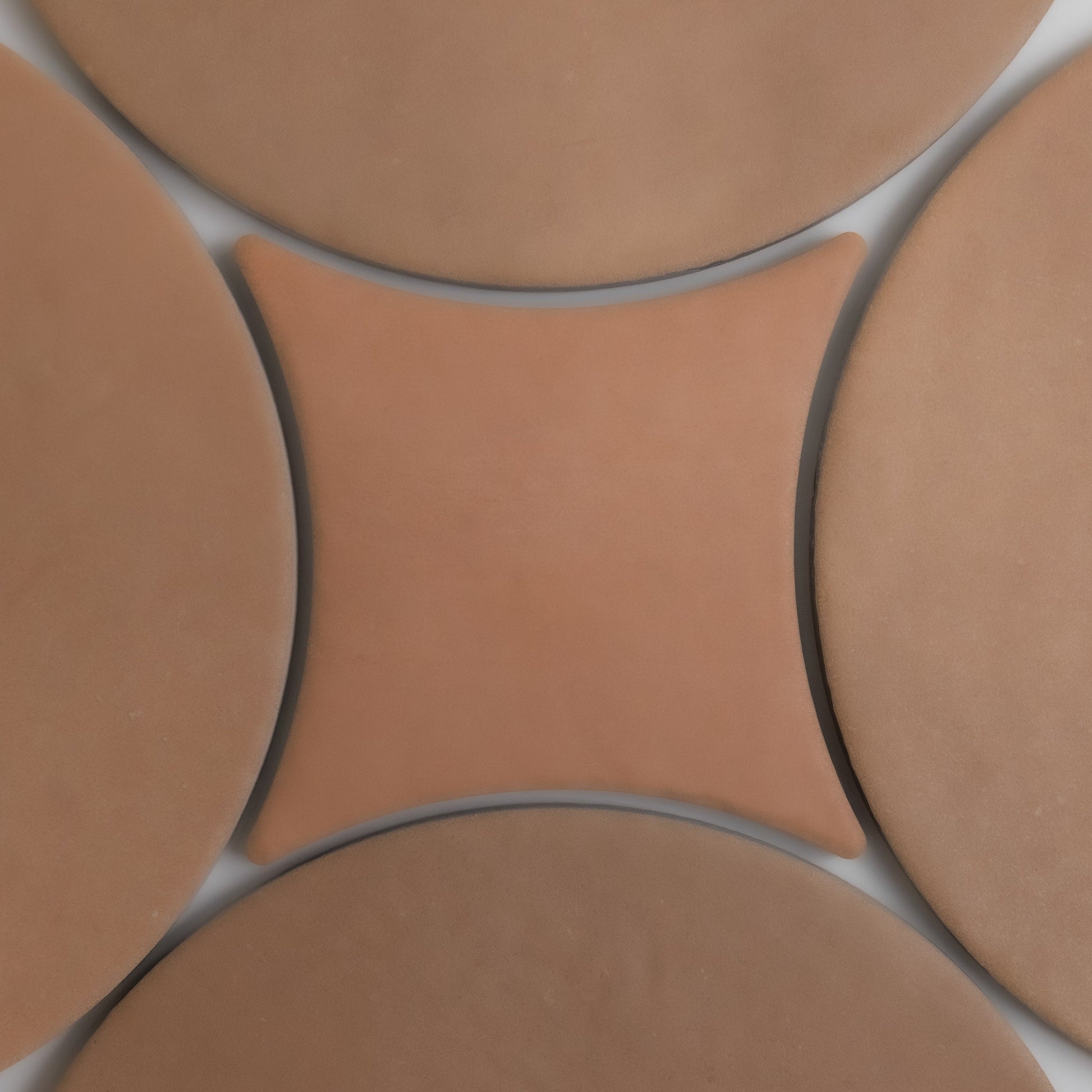 Five tan and brown Arcilla tiles by Finca form a geometric pattern with a concave square tile at the center.