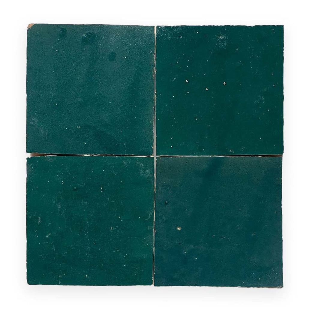 Four dark green square tiles arranged in a 2x2 grid, with slight imperfections and gaps between them.