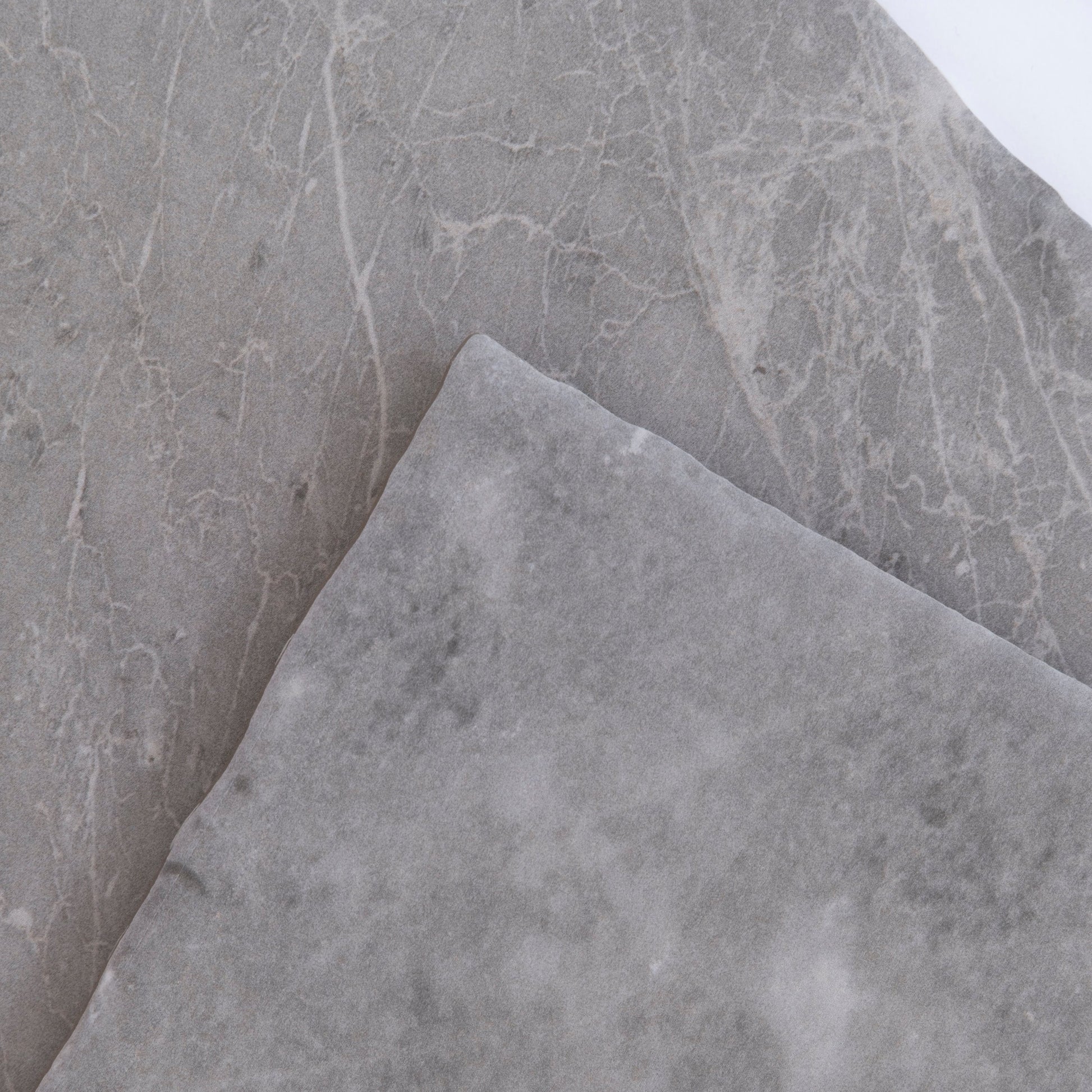 Two overlapping Tosca Bardiglio samples show smooth gray surfaces with subtle white veining.