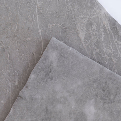 Two overlapping Tosca Bardiglio samples show smooth gray surfaces with subtle white veining.