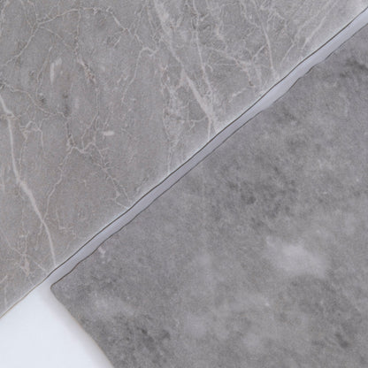 Two overlapping Tosca Bardiglio marble samples in gray with varied textures and subtle white veining.