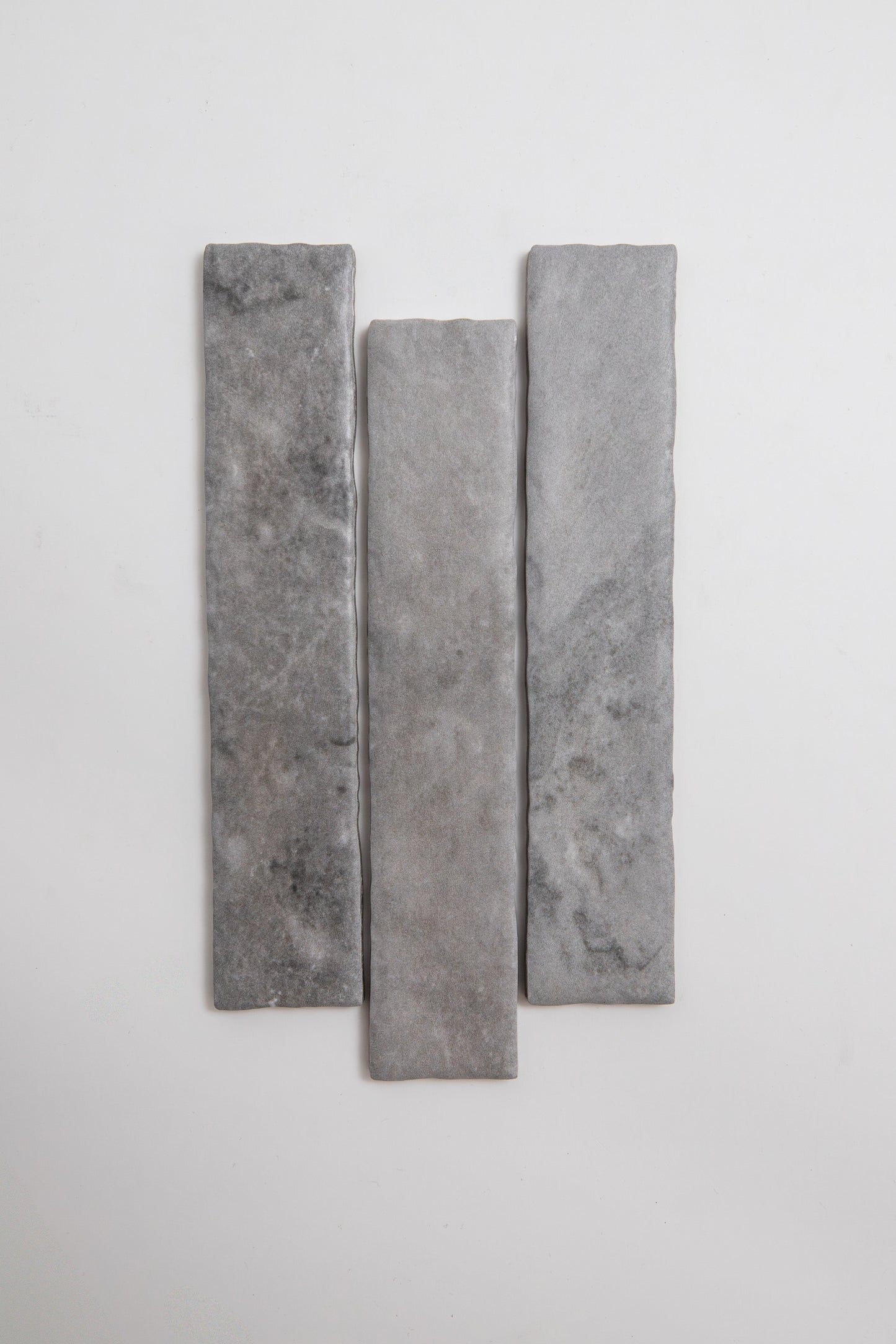 Three Bardiglio rectangular gray stone tiles by Tosca, arranged vertically on a plain white background.