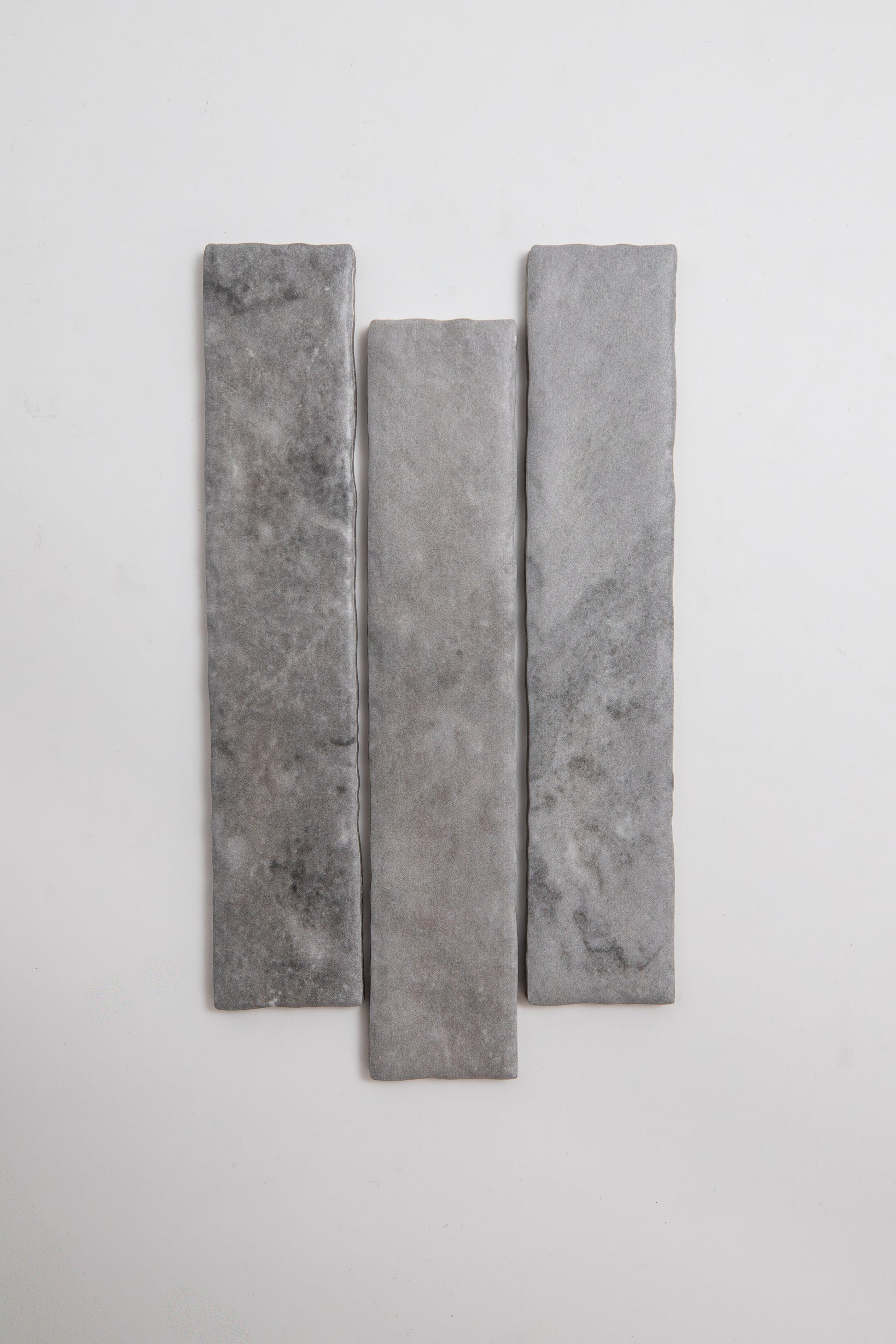 Three Bardiglio rectangular gray stone tiles by Tosca, arranged vertically on a plain white background.
