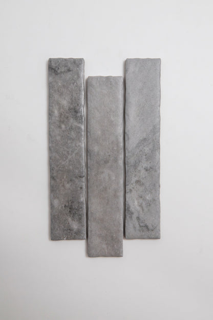 Three Bardiglio rectangular gray stone tiles by Tosca, arranged vertically on a plain white background.