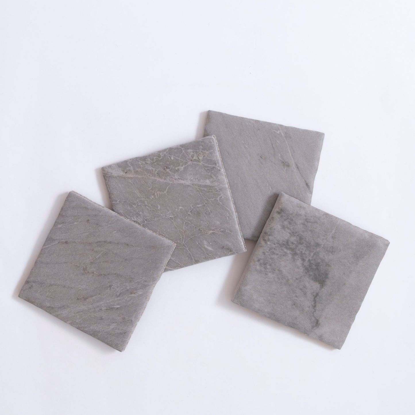 Four Bardiglio gray stone tile samples by Tosca, arranged in overlapping squares on a white background.