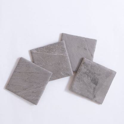 Four Bardiglio gray stone tile samples by Tosca, arranged in overlapping squares on a white background.