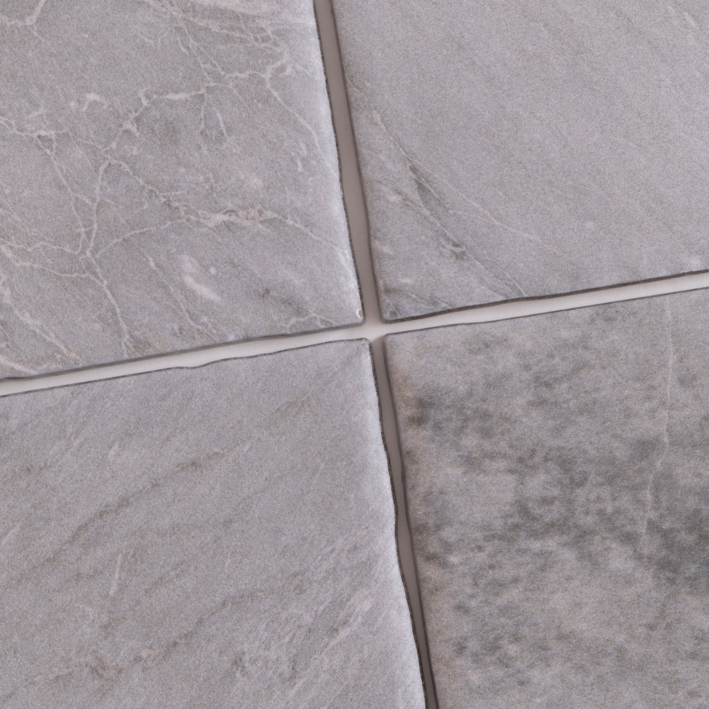 Four Bardiglio Sample tiles by Tosca in gray, with varied textures and white veining, separated by thin grout lines.
