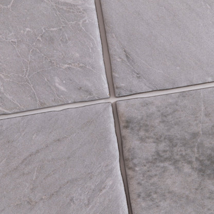 Four Bardiglio Sample tiles by Tosca in gray, with varied textures and white veining, separated by thin grout lines.