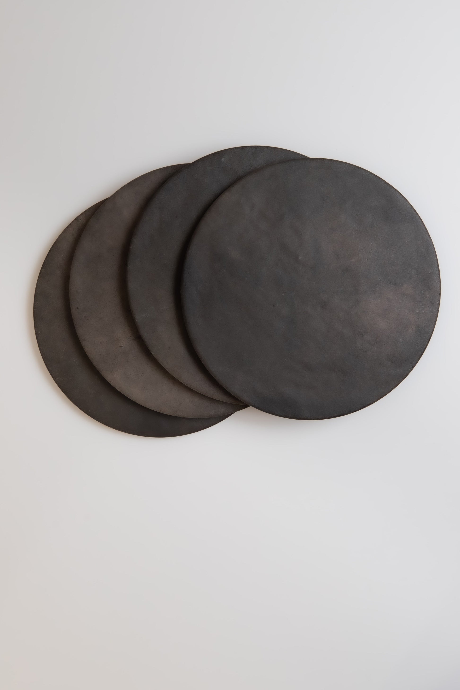 Four round Finca Black Horse, Extra Sample mats overlap on a white background.