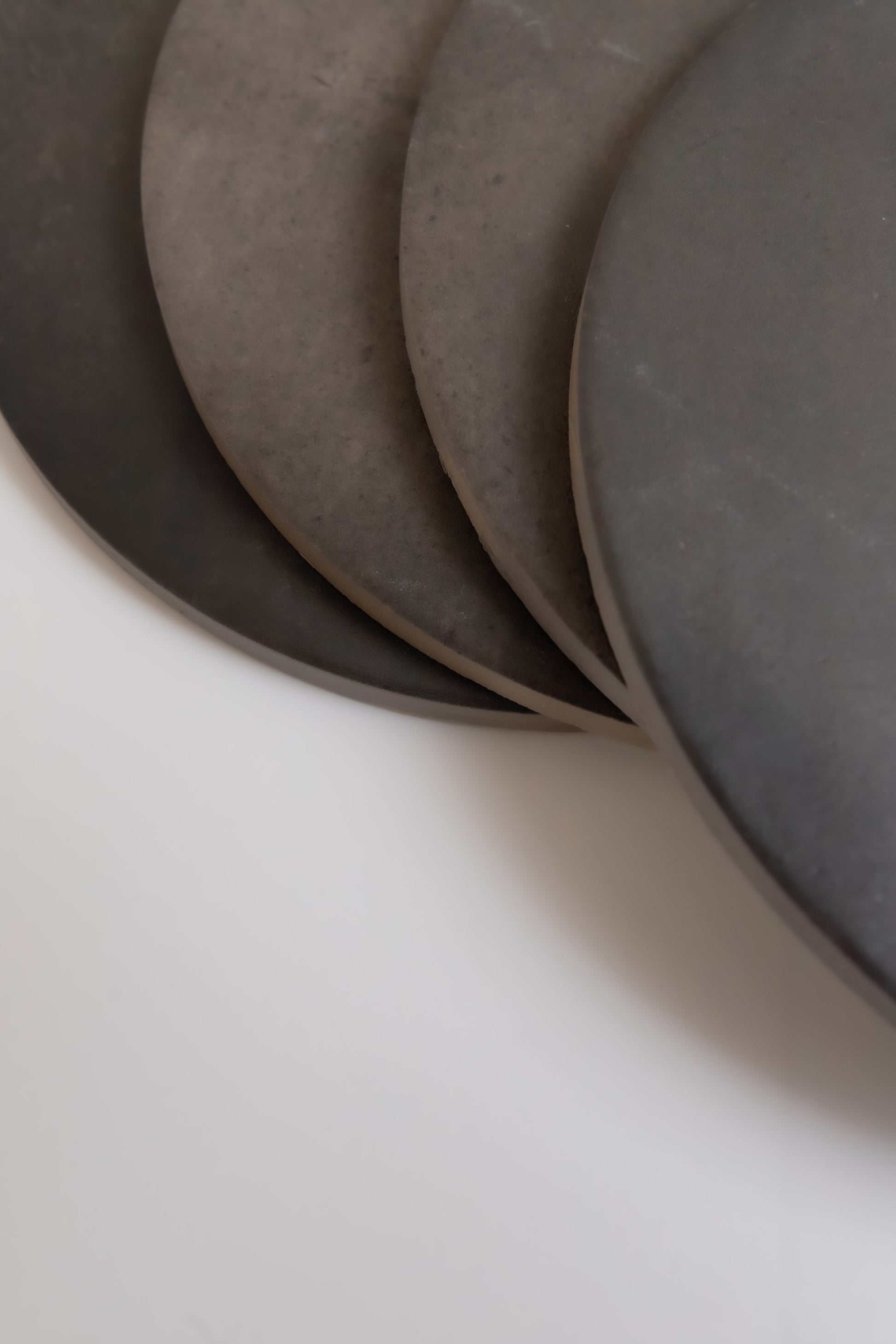 Four "Black Horse, Extra Sample" plates by Finca are stacked closely on a white surface.