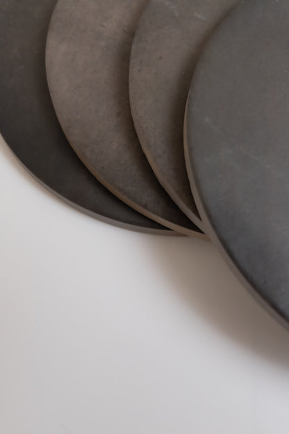 Four "Black Horse, Extra Sample" plates by Finca are stacked closely on a white surface.