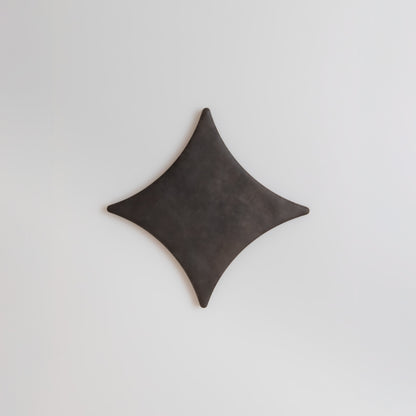 The Finca Black Horse, Extra Sample features a dark, diamond-shaped object with curved edges on a white background.