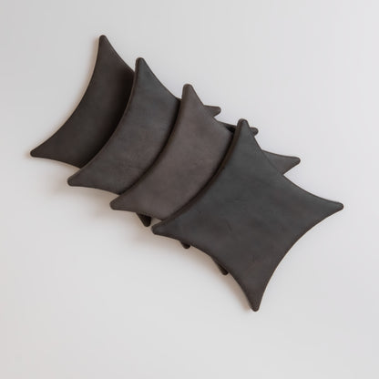 Four Black Horse, Extra Sample ceramic plates by Finca overlap diagonally on a light background.