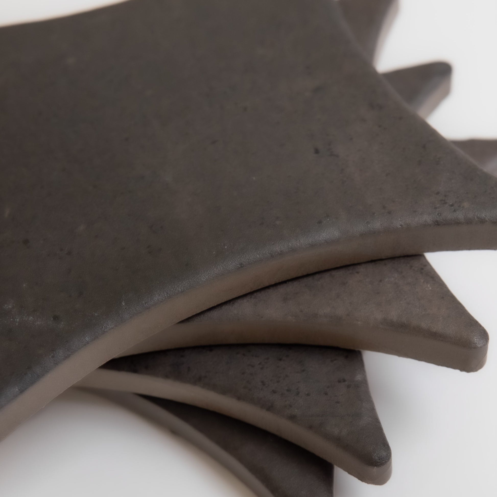 Four Black Horse, Extra Sample tiles by Finca are stacked diagonally with their edges and corners overlapping.