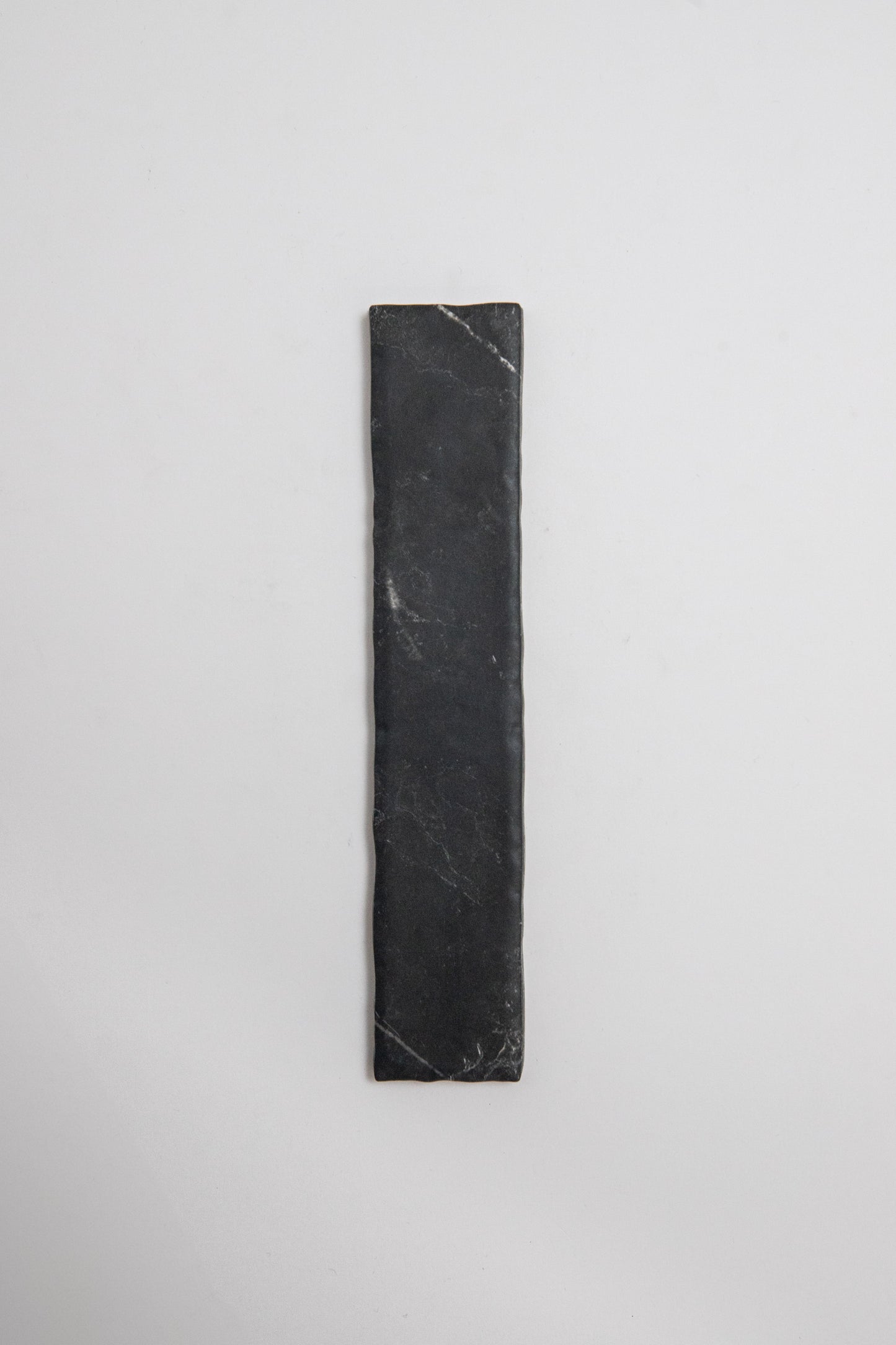 A Tosca Black Marble, Extra Sample, is placed vertically on a plain white background.